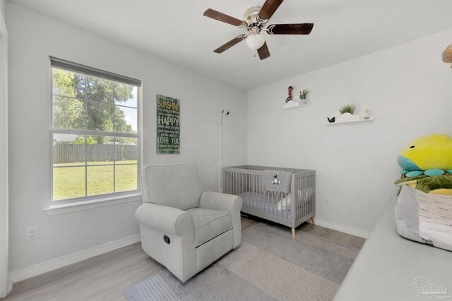 6439 Dallas Ave, Pensacola, FL 32526 - bedroom with baseboards, a ceiling fan, light wood-type flooring, and a crib