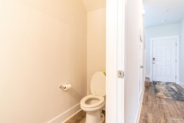 bathroom with hardwood / wood-style flooring and toilet