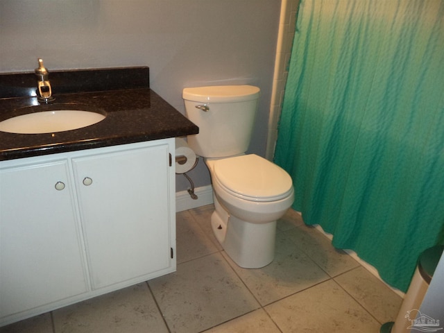 bathroom featuring toilet, vanity, tile patterned floors, and curtained shower