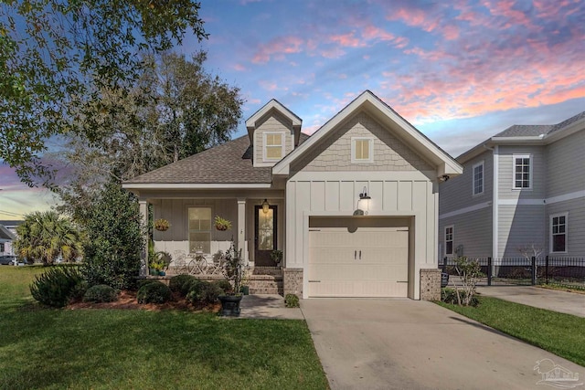 view of front of property with a garage, a yard, and covered porch