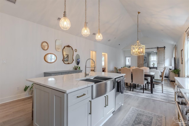 920 W Chase St, Pensacola, FL 32502 - kitchen with decorative light fixtures, white cabinetry, an island with sink, sink, and light stone counters