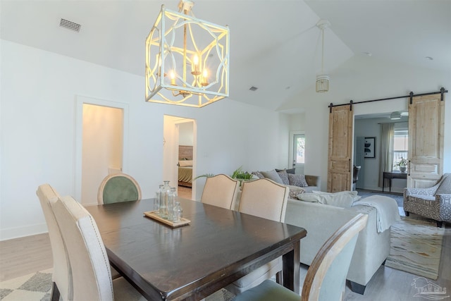 920 W Chase St, Pensacola, FL 32502 - dining space featuring lofted ceiling, light hardwood / wood-style floors, a barn door, and an inviting chandelier