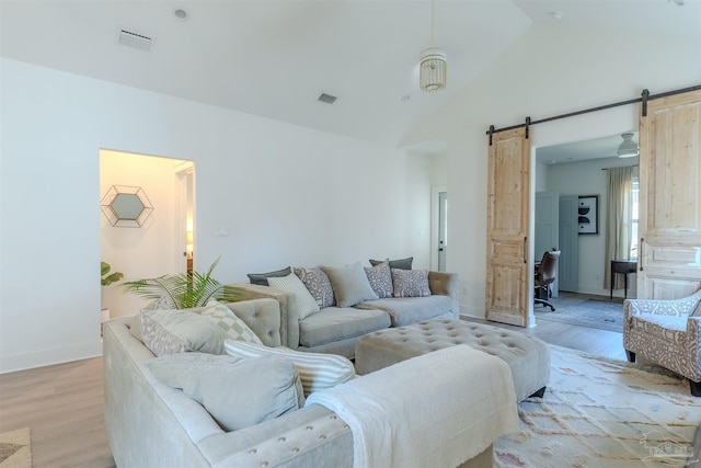 920 W Chase St, Pensacola, FL 32502 - living room featuring high vaulted ceiling, a barn door, and light wood-type flooring