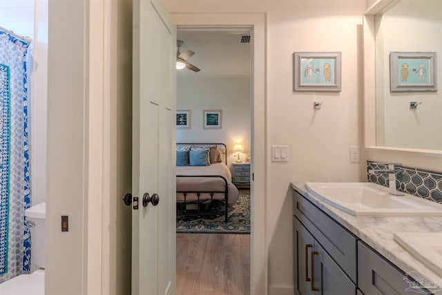 920 W Chase St, Pensacola, FL 32502 - bathroom featuring tasteful backsplash, a shower with curtain, vanity, ceiling fan, and hardwood / wood-style floors