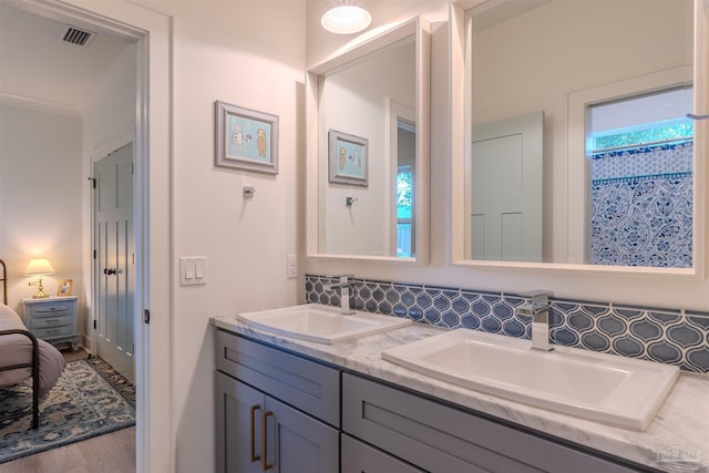 920 W Chase St, Pensacola, FL 32502 - bathroom featuring hardwood / wood-style flooring, vanity, and backsplash
