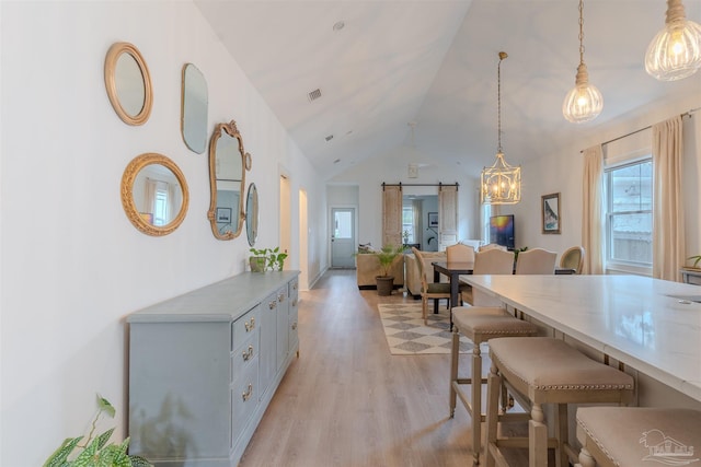 920 W Chase St, Pensacola, FL 32502 - dining room with high vaulted ceiling, light hardwood / wood-style floors, and a barn door