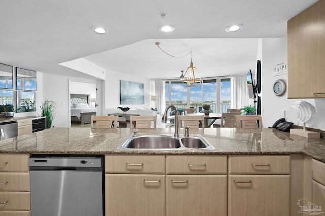 kitchen with light stone countertops, light brown cabinets, and a sink