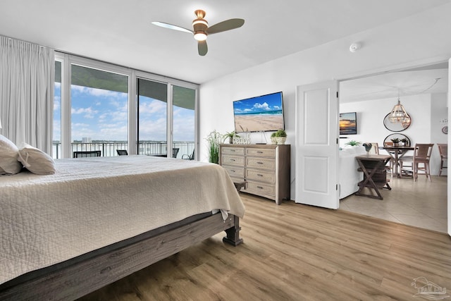 bedroom featuring access to exterior, ceiling fan, and light wood-style flooring