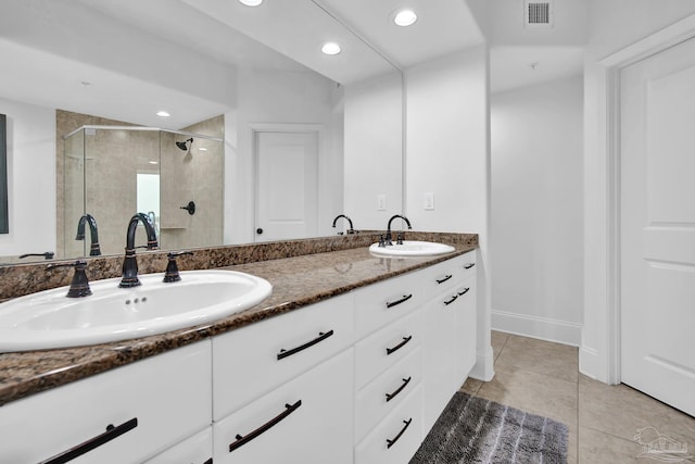 full bathroom featuring double vanity, a stall shower, visible vents, and a sink