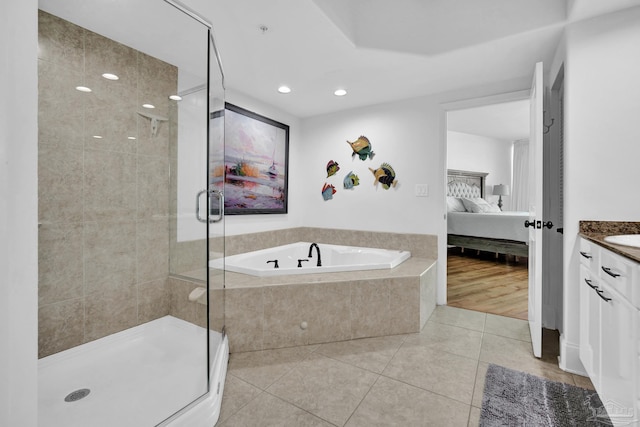 ensuite bathroom featuring a stall shower, a garden tub, connected bathroom, and tile patterned floors