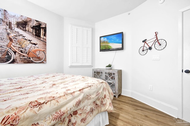 bedroom featuring baseboards and wood finished floors