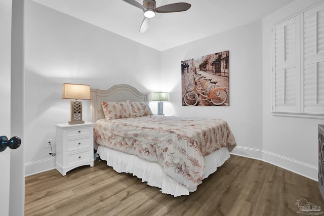 bedroom with ceiling fan, baseboards, and wood finished floors