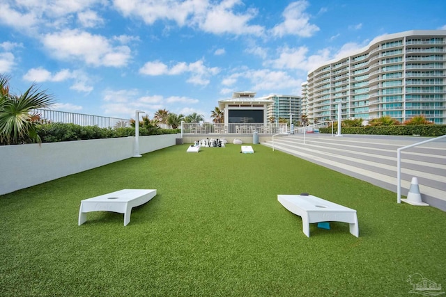 view of property's community with fence and a lawn