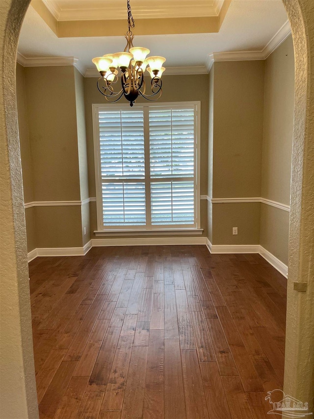 spare room featuring ornamental molding, an inviting chandelier, and dark hardwood / wood-style floors