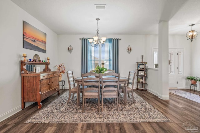 dining room featuring a chandelier, wood finished floors, baseboards, and visible vents