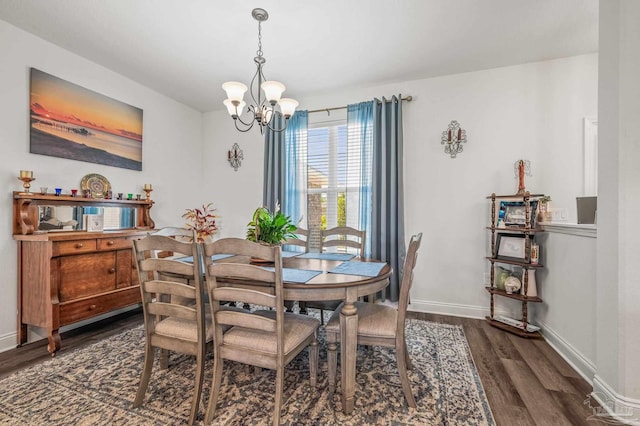dining room with baseboards, a chandelier, and wood finished floors
