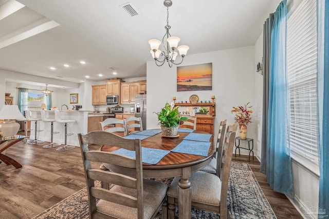 dining area with a chandelier, dark wood-style floors, and visible vents