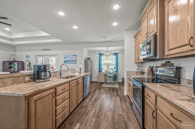 kitchen with a sink, dark wood-style floors, recessed lighting, stainless steel appliances, and light stone counters