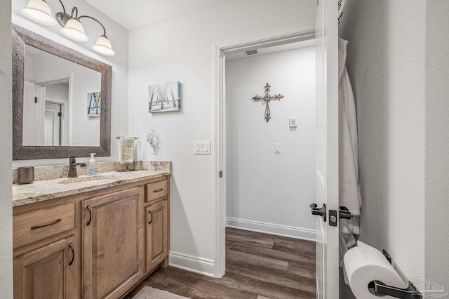 bathroom featuring wood finished floors, vanity, and baseboards