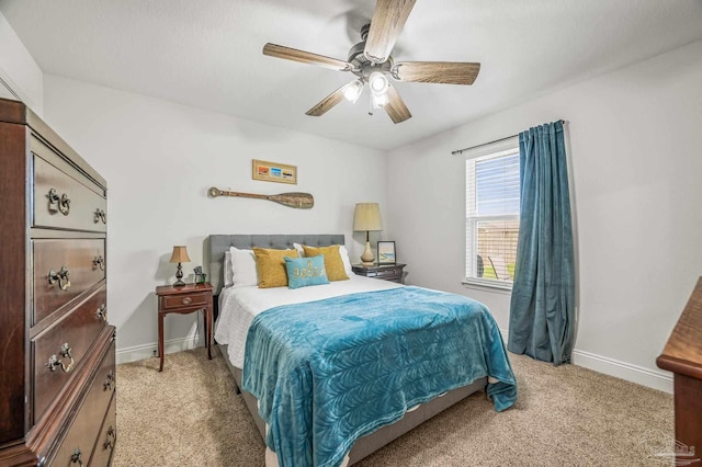 bedroom featuring light colored carpet, baseboards, and ceiling fan