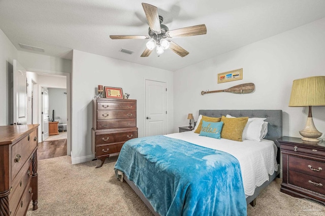carpeted bedroom with visible vents and ceiling fan