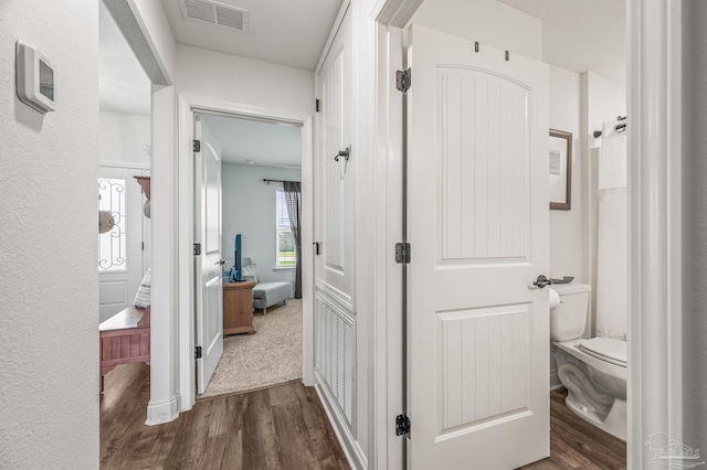 hallway with visible vents and dark wood-style flooring
