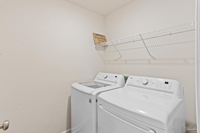 laundry room with baseboards, laundry area, and washer and dryer