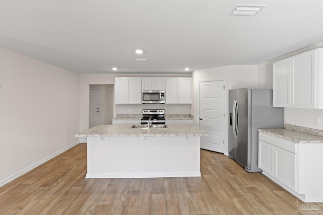 kitchen with stainless steel appliances, light wood-type flooring, a sink, and a center island with sink