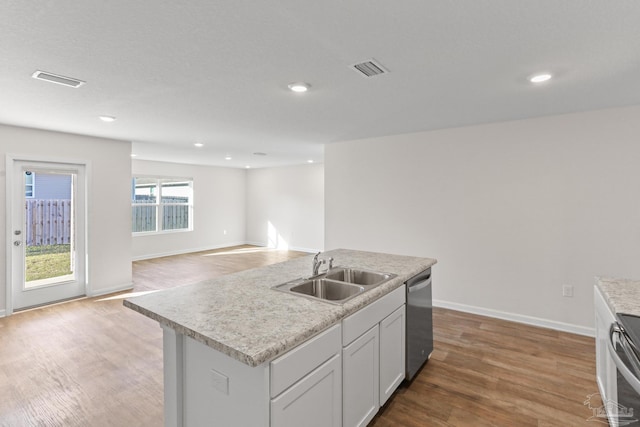 kitchen with light wood-style floors, appliances with stainless steel finishes, light countertops, and a sink