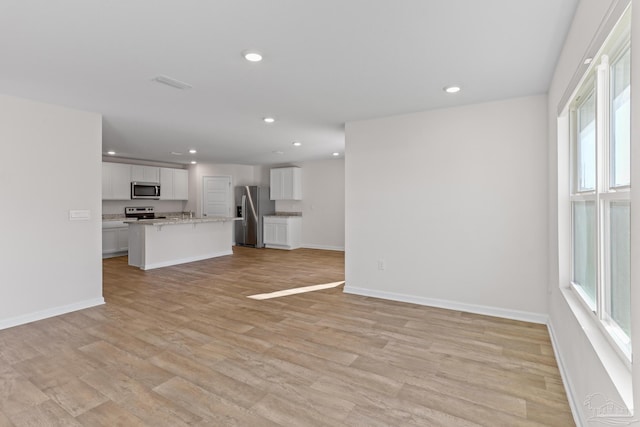 unfurnished living room with light wood-style floors, visible vents, baseboards, and recessed lighting