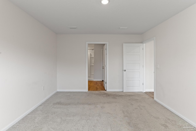 carpeted spare room featuring baseboards