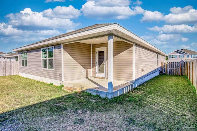 view of side of property featuring a lawn, a patio area, and a fenced backyard