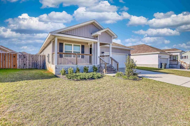 view of front of home featuring covered porch, an attached garage, a front yard, fence, and driveway