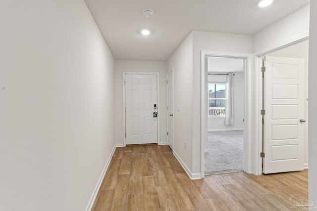 hall with light wood finished floors, recessed lighting, and baseboards