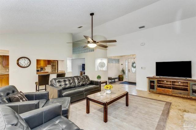 living room with high vaulted ceiling, ceiling fan, and a textured ceiling