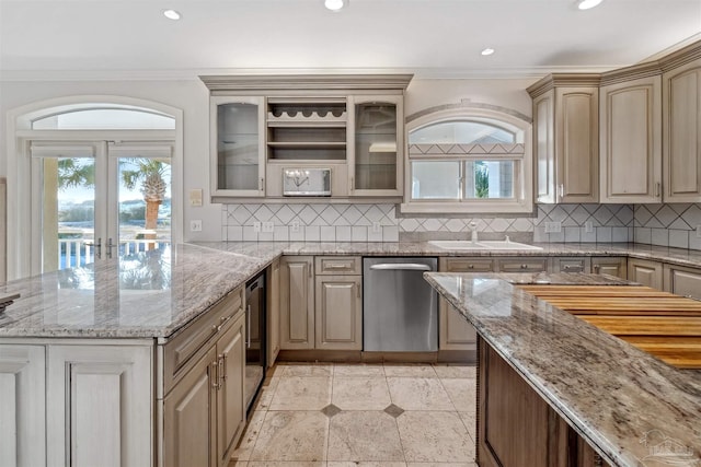 kitchen with tasteful backsplash, sink, light stone counters, and dishwasher