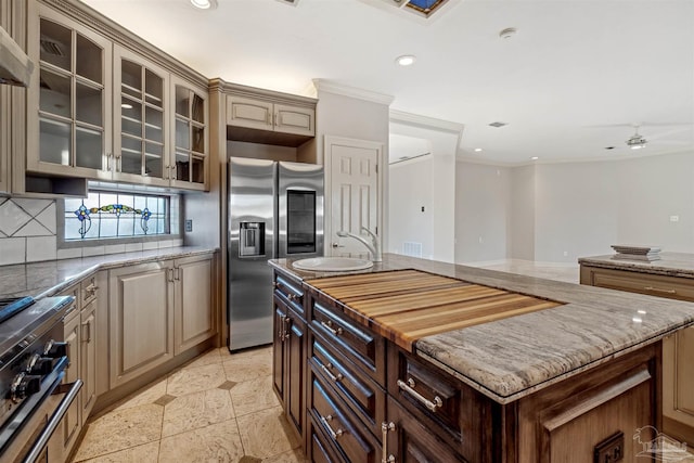 kitchen with sink, tasteful backsplash, range, a center island, and stainless steel fridge with ice dispenser