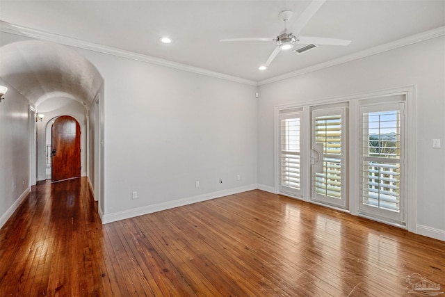 spare room with dark wood-type flooring, ceiling fan, and ornamental molding