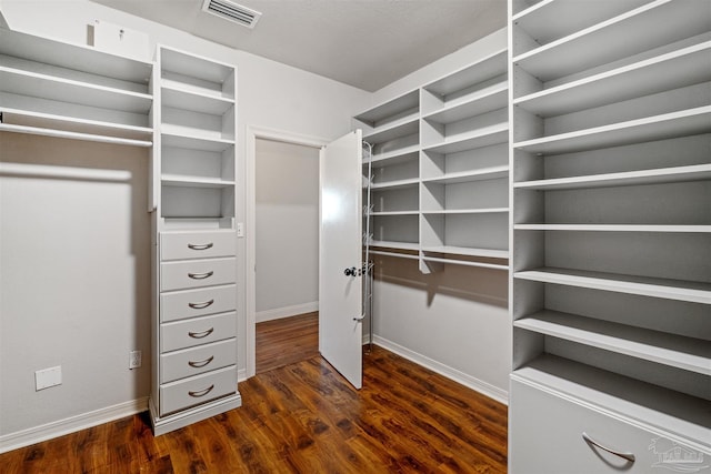 spacious closet with dark hardwood / wood-style floors