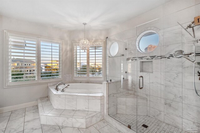 bathroom featuring independent shower and bath and a chandelier