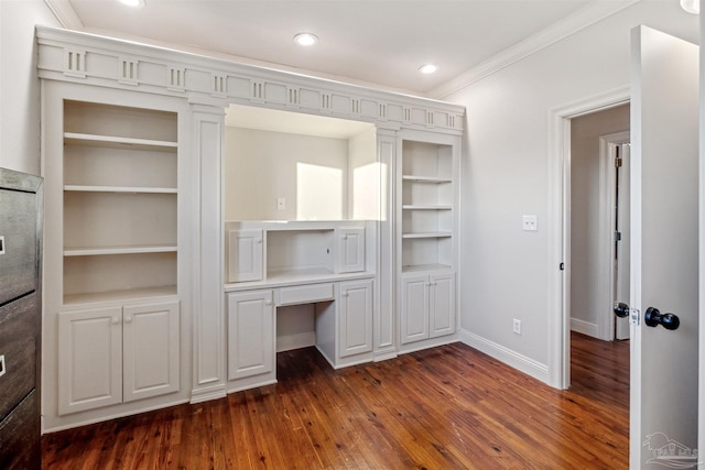 interior space featuring dark hardwood / wood-style flooring, built in shelves, and ornamental molding