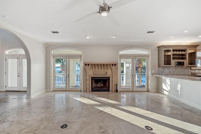 unfurnished living room with french doors, ceiling fan, and crown molding