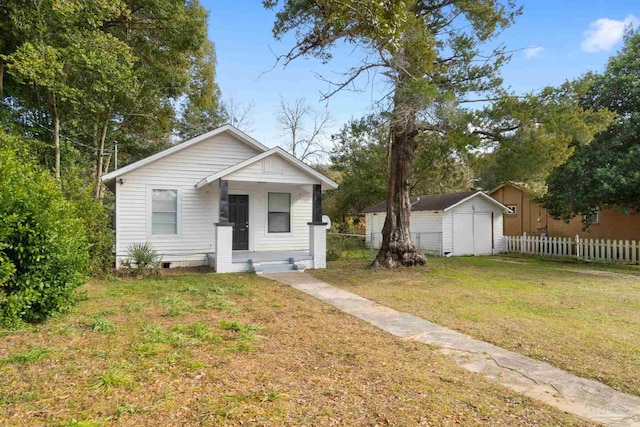 view of front of property featuring a front lawn and a shed