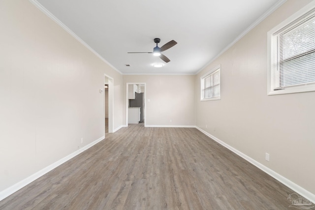 spare room with hardwood / wood-style flooring, crown molding, and ceiling fan