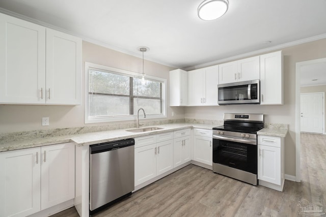 kitchen with sink, hanging light fixtures, ornamental molding, stainless steel appliances, and white cabinets