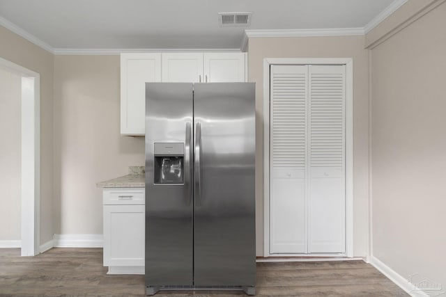 kitchen featuring stainless steel fridge with ice dispenser, ornamental molding, and white cabinets