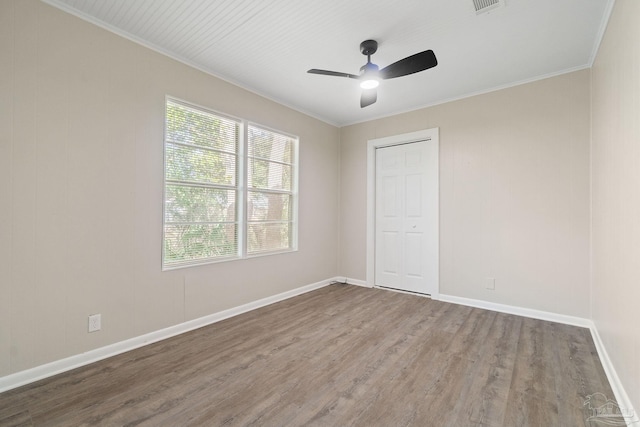 spare room with crown molding, ceiling fan, and wood-type flooring