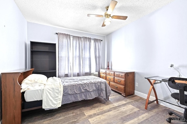 bedroom with ceiling fan, radiator heating unit, wood-type flooring, and a textured ceiling