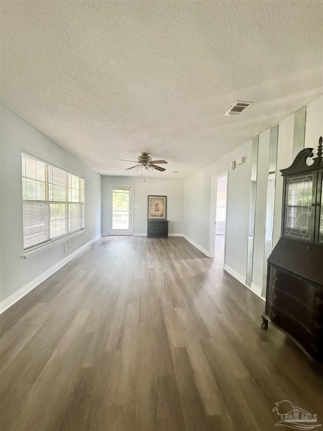 941 Summer Shade Ln, Cantonment, FL 32533 - unfurnished living room with a textured ceiling, wood finished floors, a ceiling fan, and baseboards