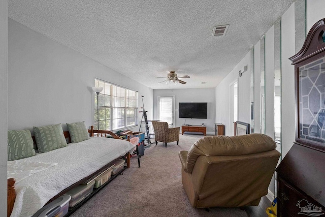 bedroom featuring ceiling fan, light colored carpet, and a textured ceiling